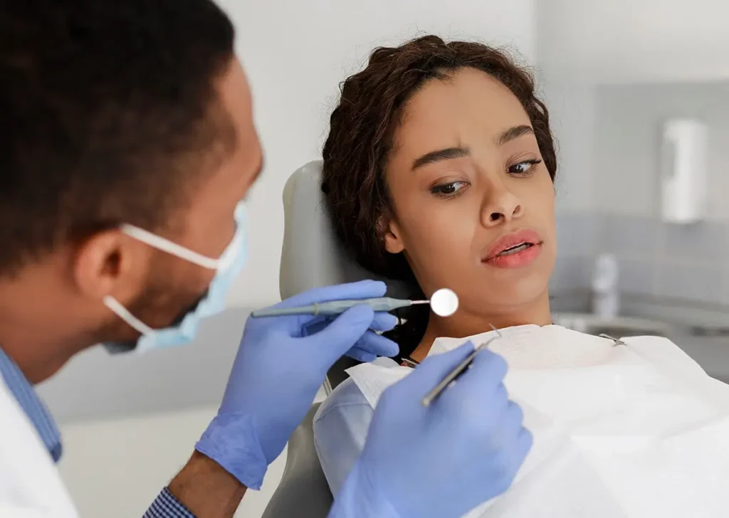 Worried patient looking at tools the dentist is holding.