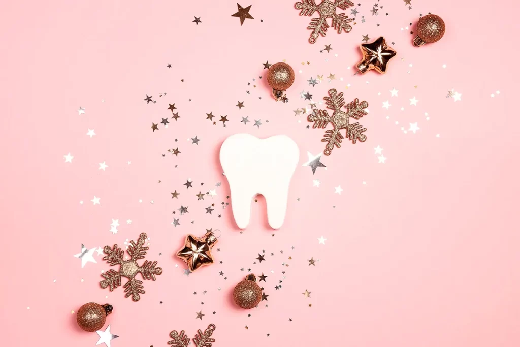 Tooth decoration surrounded by stars, ornaments, and snowflakes.