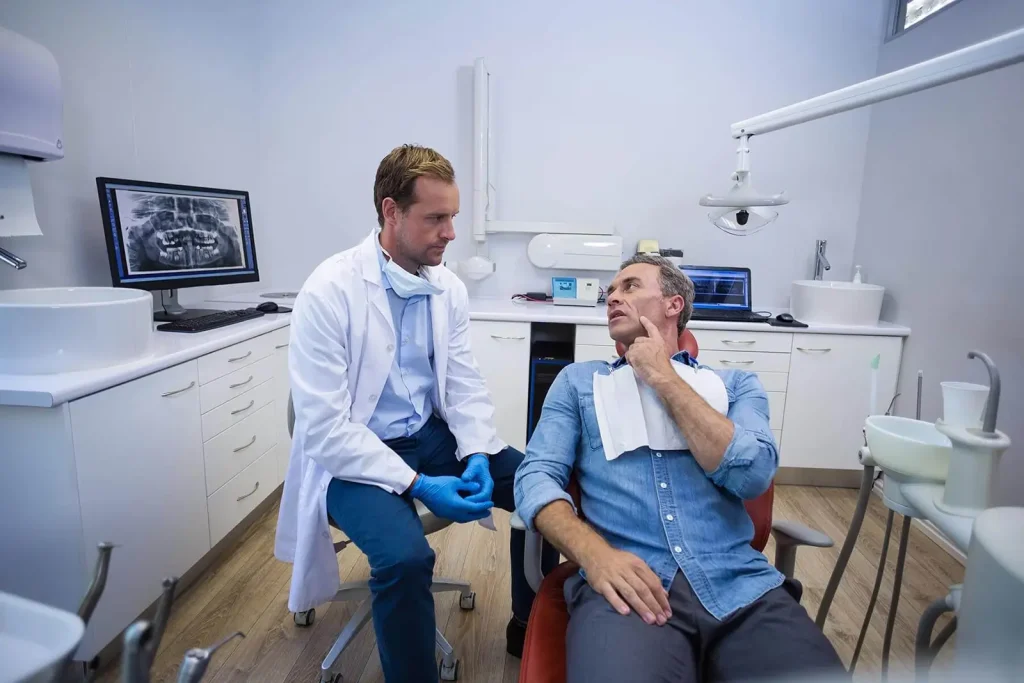 Patient talking to dentist in dental office.